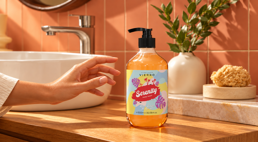 Vierro Serenity hand wash on a wooden bathroom counter, with a hand reaching nearby, warm sunlight, terracotta tiles, a white sink, and green foliage.