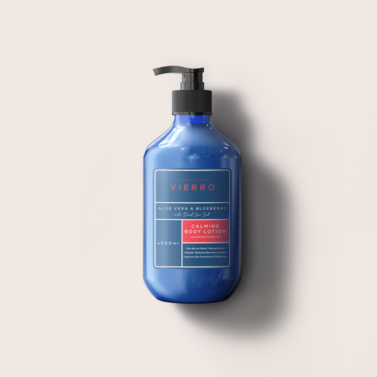 A bottle of VIERRO exfoliating hand wash in a deep cobalt blue color with a black pump dispenser, set against a solid light beige background with a soft shadow.