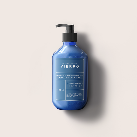A bottle of VIERRO exfoliating hand wash in a deep cobalt blue color with a black pump dispenser, set against a solid light beige background with a soft shadow.