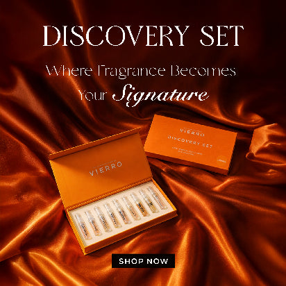 Vierro featuring an open luxury discovery set box displaying ten miniature fragrance vials alongside a matching orange gift box, set against a glossy, draped orange satin fabric background with text reading "Discovery Set, Where Fragrance Becomes Your Signature, Shop Now."